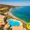 Veduta aerea di un resort con piscina e spiaggia.