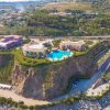 Resort su una scogliera con piscina centrale.