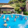 Persone in piscina partecipano ad attività acquatiche.