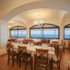 Sala da pranzo con vista sul mare e finestre ampie.