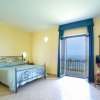 Camera da letto con letto matrimoniale, balcone e vista mare.