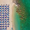 Ombrelloni su spiaggia vista dall'alto.