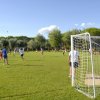 Partita di calcio su un campo verde con spettatori.