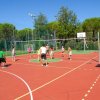 Persone giocano a pallavolo su un campo all'aperto.