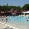 Piscina all'aperto con molte persone che nuotano.