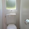 Toilette con finestra opaca e carta igienica.