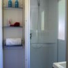 Bagno con doccia e scaffali con asciugamani.