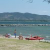 Spiaggia con persone, kayak rosso e montagne.