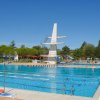 Piscina grande con trampolini e bagnanti.
