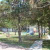 Area giochi con altalene circondata da alberi.