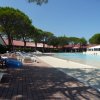 Piscina con lettini e persone che si rilassano.