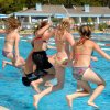 Bambini che saltano in piscina.