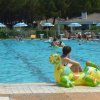 Piscina con giochi gonfiabili e persone in acqua.