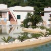 Piscina con isola di palme e lettini bianchi esterni.