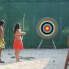 Persone praticano tiro con l'arco all'aperto.