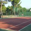 Gioco di tennis in corso su un campo all'aperto.