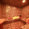 Sauna con mosaico e persone su panche.
