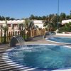 Due piscine all'aperto con cascate, circondate da alberi.