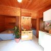 Interno di legno con letto, pianta e cucina piccola.