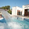 Una piscina con cascata d'acqua di fronte a un centro benessere.
