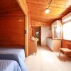 Interno di bungalow di legno con letti e angolo cucina.