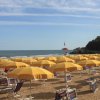 Spiaggia con ombrelloni gialli e mare.