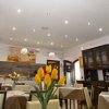 Sala ristorante elegante, vista da un diverso angolo, con tulipani su un tavolo.