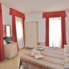 Camera da letto in hotel con tende rosse, armadio e letto matrimoniale.