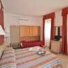 Camera da letto con letto matrimoniale, letto singolo, e finestra con tende rosse.