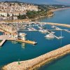 Una marina con barche e una città costiera sullo sfondo.